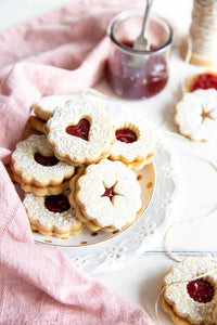 Linzer cookies are a combination of buttery orange infused shortbread and jam, as pleasing to look at as they are to eat